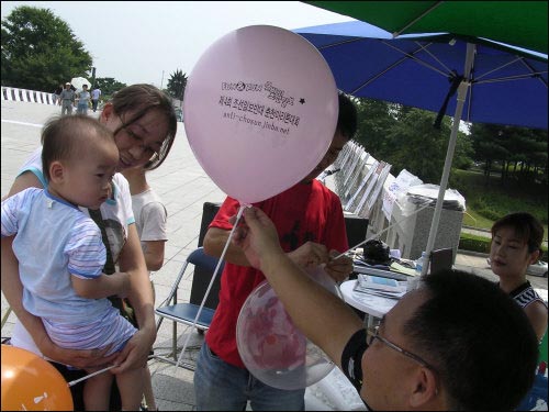 시민들에게 풍선을 나눠주고 있는 <조선일보 반대운동> 주최 노사모팀 